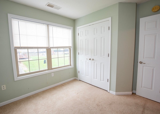 unfurnished bedroom with a closet and light carpet