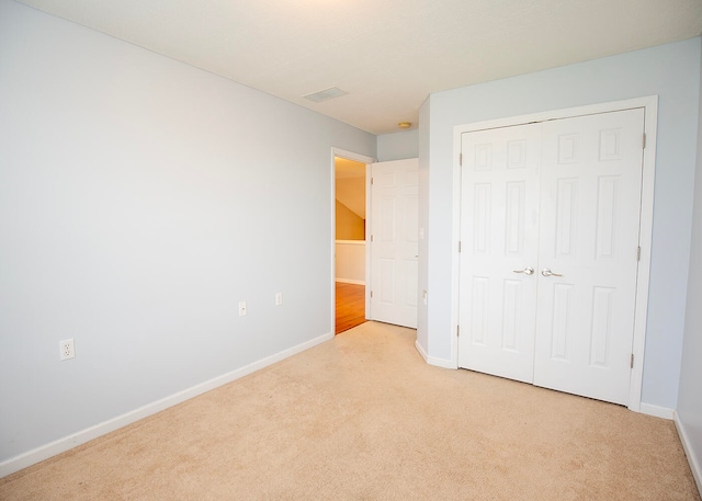 unfurnished bedroom featuring a closet and light carpet