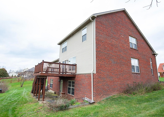 view of side of property with a lawn and a wooden deck