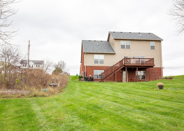 rear view of house with central AC, a yard, and a wooden deck