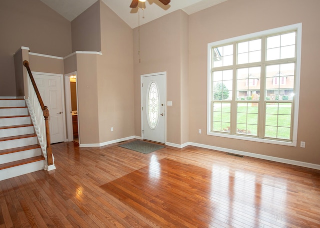 foyer with high vaulted ceiling, ceiling fan, and light hardwood / wood-style floors