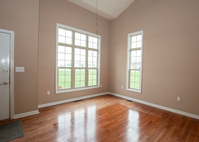 empty room featuring light hardwood / wood-style floors and high vaulted ceiling