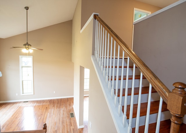 staircase with lofted ceiling, ceiling fan, and hardwood / wood-style flooring