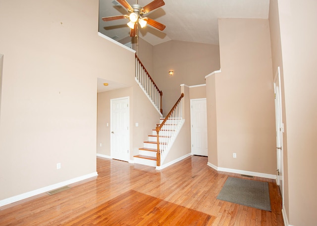 interior space featuring ceiling fan, light wood-type flooring, and high vaulted ceiling