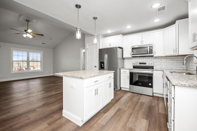 kitchen with stainless steel appliances, sink, decorative light fixtures, white cabinetry, and decorative backsplash