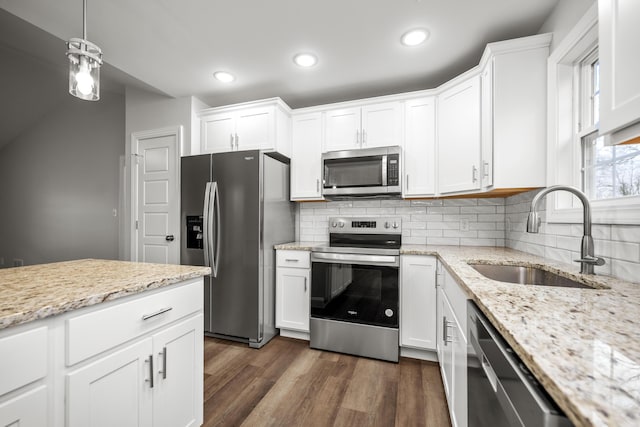 kitchen featuring dark wood-style floors, stainless steel appliances, backsplash, white cabinets, and a sink