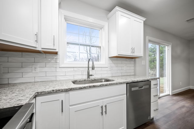 kitchen with sink, stainless steel dishwasher, light stone counters, and white cabinetry