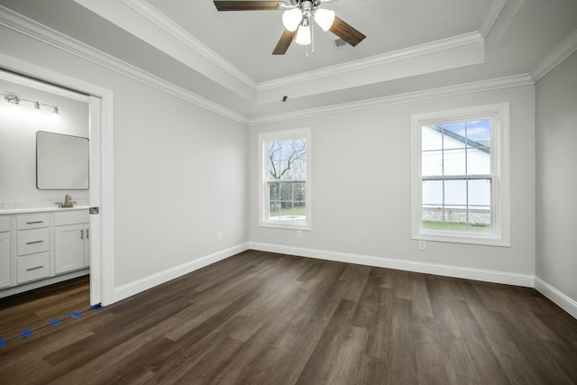 unfurnished bedroom with connected bathroom, ceiling fan, ornamental molding, a tray ceiling, and sink