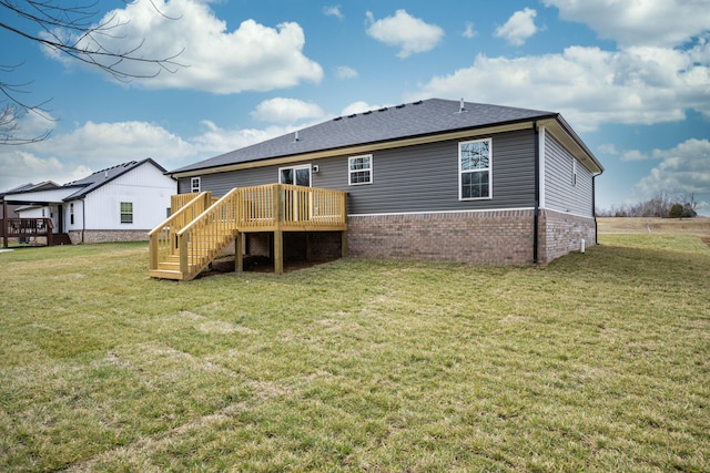 back of property featuring a lawn, stairway, roof with shingles, a wooden deck, and brick siding