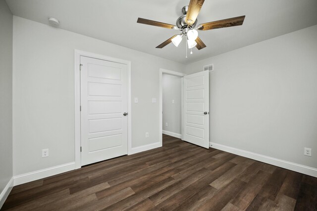 empty room featuring ceiling fan and dark hardwood / wood-style flooring