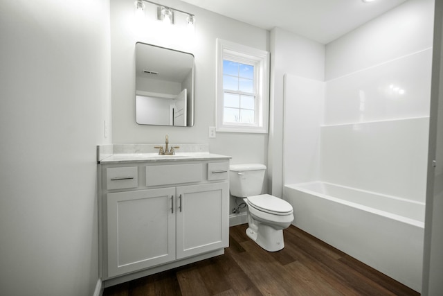 full bathroom with bathing tub / shower combination, toilet, vanity, and wood-type flooring