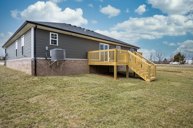 back of house featuring brick siding, a yard, central AC unit, a deck, and stairs