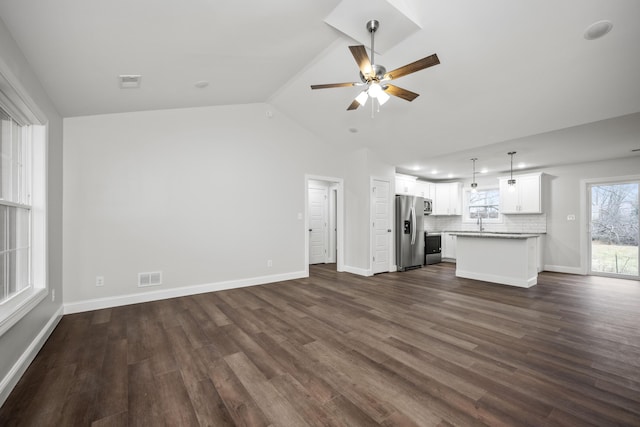 unfurnished living room featuring ceiling fan, dark wood-type flooring, vaulted ceiling, and sink