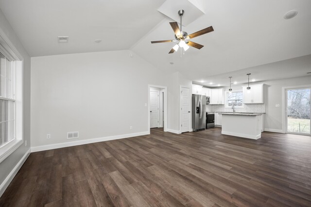 unfurnished living room featuring vaulted ceiling, ceiling fan, dark hardwood / wood-style flooring, and sink