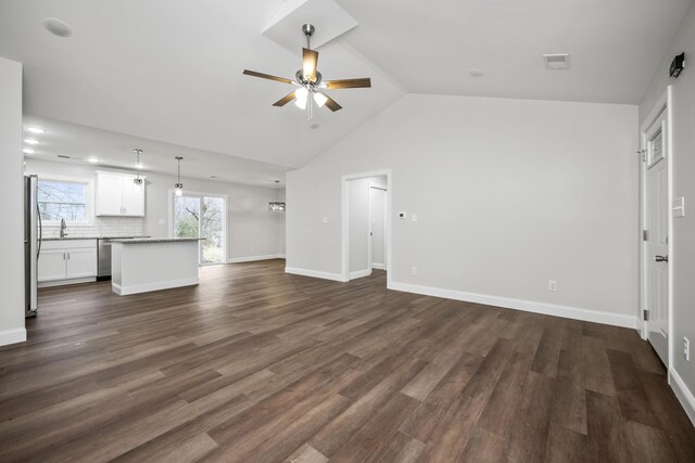 kitchen with a center island, hanging light fixtures, backsplash, white cabinets, and appliances with stainless steel finishes