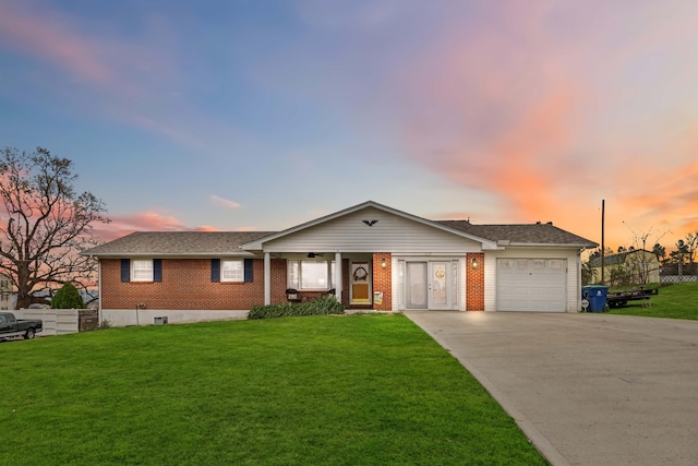 single story home featuring a lawn and a garage