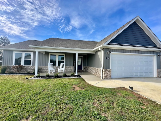 view of front of house featuring covered porch, a front yard, and a garage