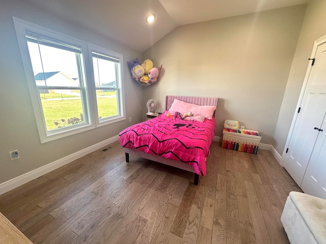 bedroom featuring hardwood / wood-style floors and lofted ceiling