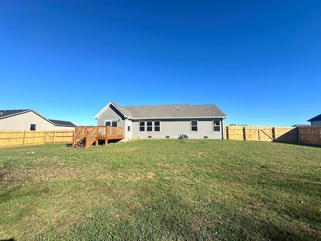 rear view of house featuring a lawn and a wooden deck