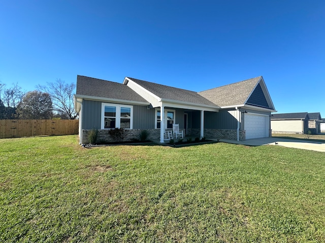 ranch-style home with covered porch, a front yard, and a garage