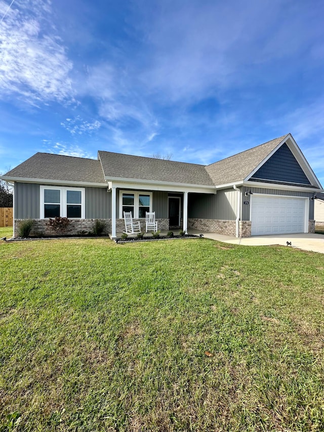 ranch-style home featuring a front yard, a garage, and covered porch