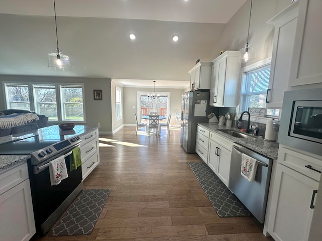 kitchen featuring light stone countertops, dark hardwood / wood-style flooring, stainless steel appliances, sink, and white cabinetry