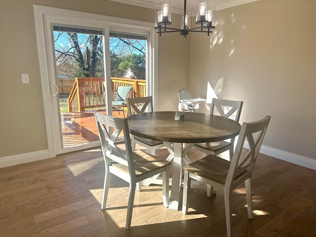 dining area featuring a chandelier, crown molding, and dark wood-type flooring