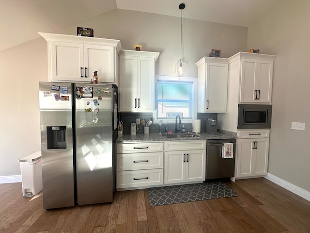 kitchen with appliances with stainless steel finishes, light stone counters, white cabinetry, and sink