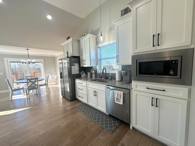 kitchen featuring sink, dark hardwood / wood-style flooring, vaulted ceiling, white cabinets, and appliances with stainless steel finishes