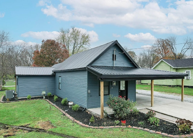 view of front of home featuring a carport, cooling unit, and a front lawn