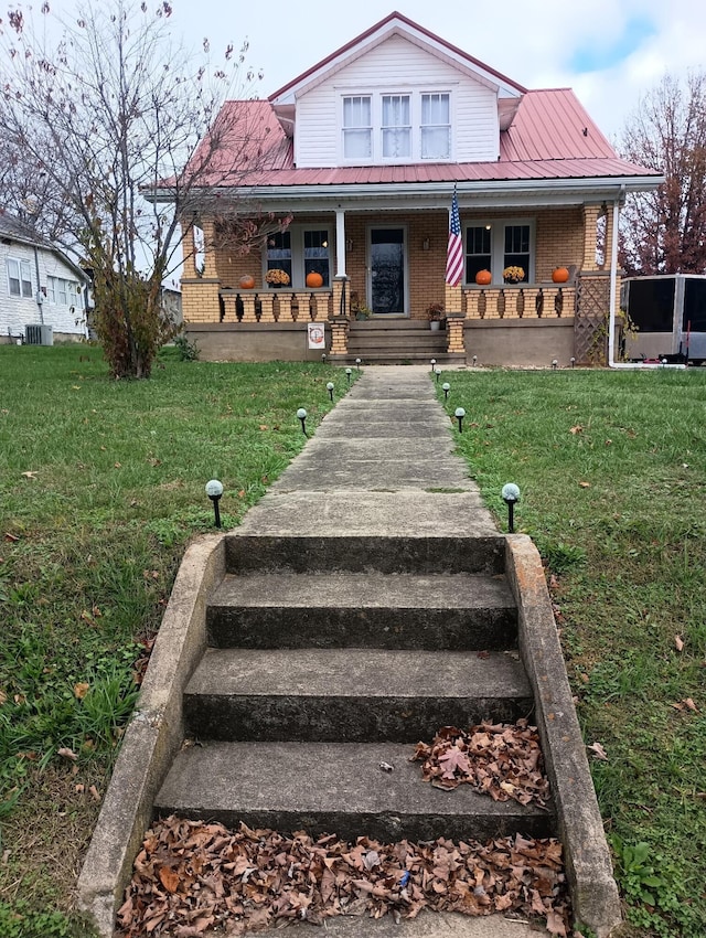 view of front facade featuring covered porch and a front lawn