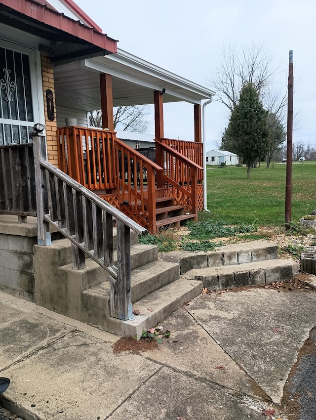 exterior space featuring covered porch and a yard