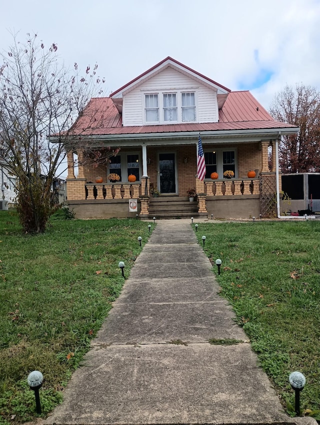 farmhouse featuring covered porch and a front yard