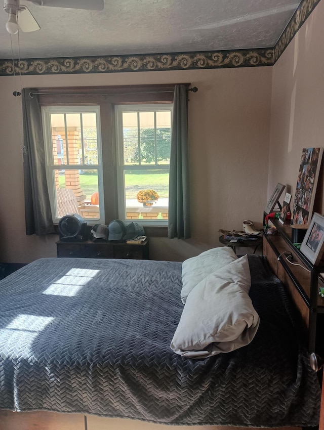 bedroom featuring ceiling fan and a textured ceiling