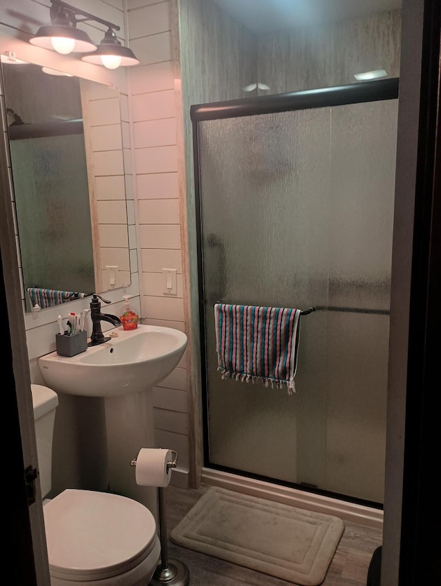 bathroom featuring hardwood / wood-style flooring, toilet, and an enclosed shower