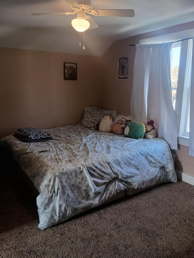 bedroom with ceiling fan, carpet floors, and vaulted ceiling