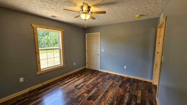 spare room with a textured ceiling, ceiling fan, and dark hardwood / wood-style floors