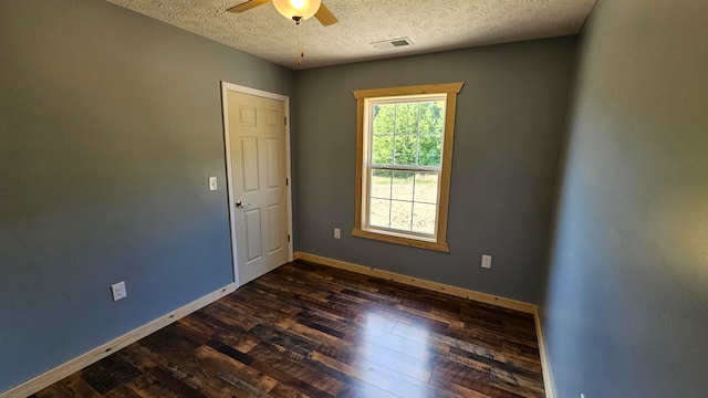 unfurnished room with dark hardwood / wood-style floors, ceiling fan, and a textured ceiling