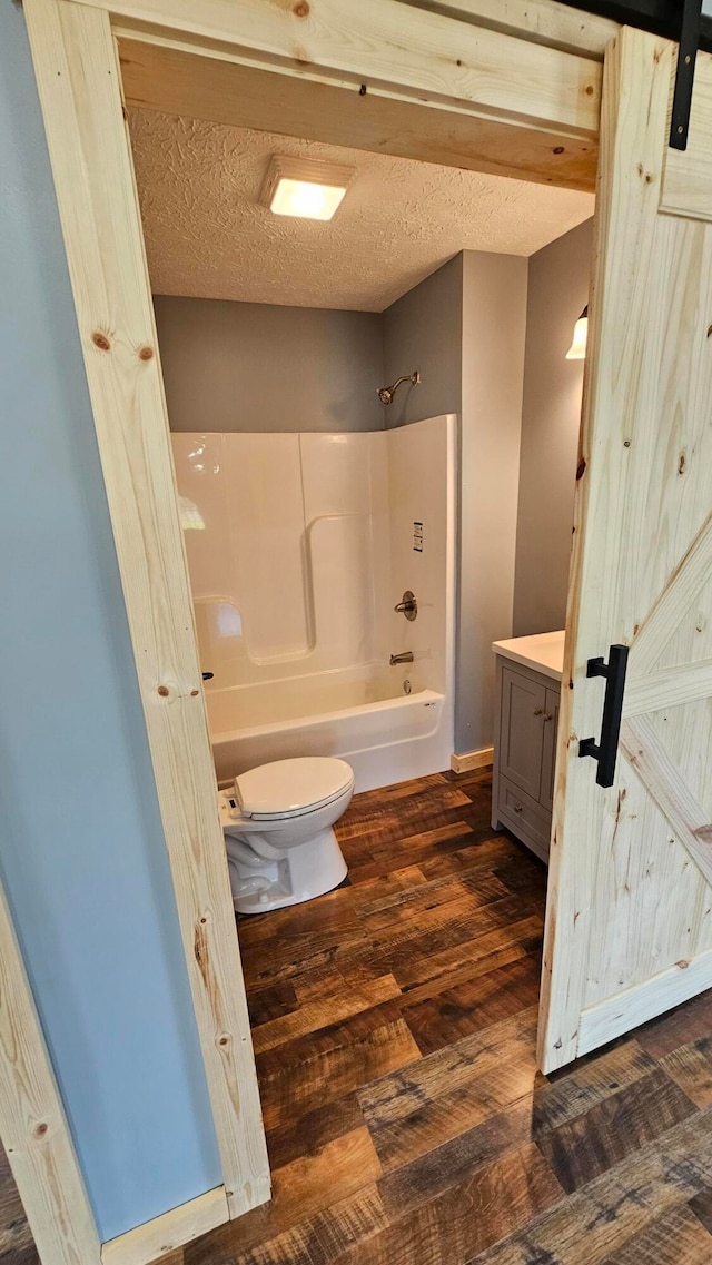 full bathroom with vanity, a textured ceiling, hardwood / wood-style flooring, and toilet