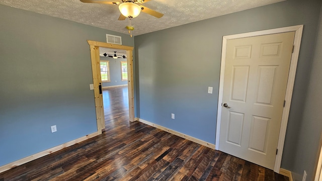 unfurnished room featuring ceiling fan, dark hardwood / wood-style flooring, and a textured ceiling