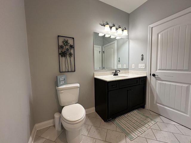 bathroom featuring vanity, toilet, and baseboards