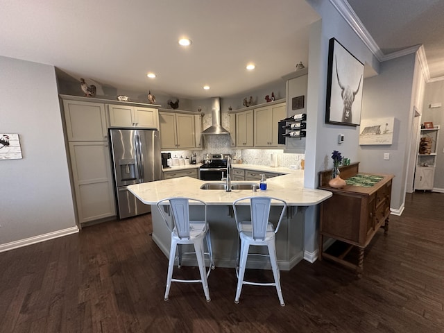 kitchen featuring a breakfast bar, tasteful backsplash, stainless steel appliances, a peninsula, and wall chimney exhaust hood