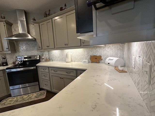 kitchen featuring stainless steel electric range oven, wall chimney exhaust hood, gray cabinets, and backsplash