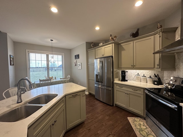 kitchen with dark wood-style flooring, a sink, appliances with stainless steel finishes, wall chimney range hood, and tasteful backsplash