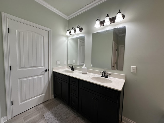 full bath with crown molding, wood finished floors, double vanity, and a sink