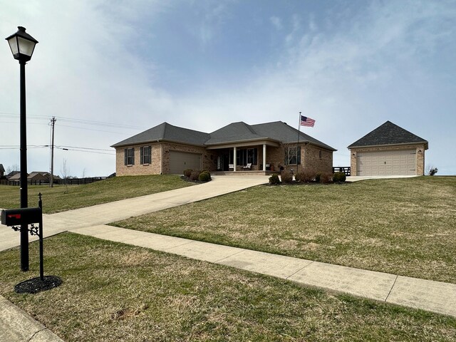 view of front of home featuring a garage, driveway, brick siding, and a front yard