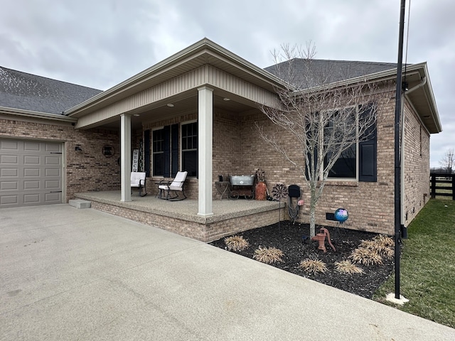 back of house with brick siding, driveway, and a garage