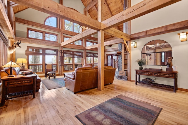 living room with high vaulted ceiling, hardwood / wood-style flooring, baseboards, and beam ceiling