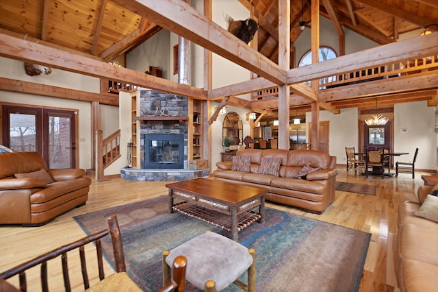 living area with lofted ceiling with beams, arched walkways, wooden ceiling, hardwood / wood-style flooring, and a fireplace