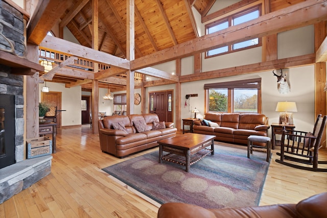 living area featuring a fireplace, an inviting chandelier, wood ceiling, beamed ceiling, and hardwood / wood-style floors